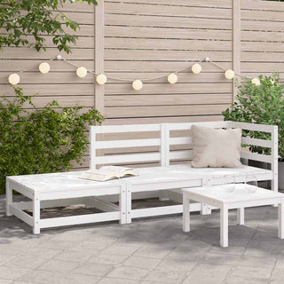 The vidaXL Garden Sofa with Footstool 2-Seater in white solid wood pine sits beside a small white table holding two glasses. String lights hang on a wooden fence, surrounded by greenery on a paved patio.