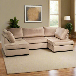 A SOFAINSTORE Oslo Beige Velvet U-Shaped Corner Sofa with Ottoman from Budget Sofa Collection sits on a light rug in a modern living room with tan walls, large windows, abstract art, a floor lamp, and two potted plants.