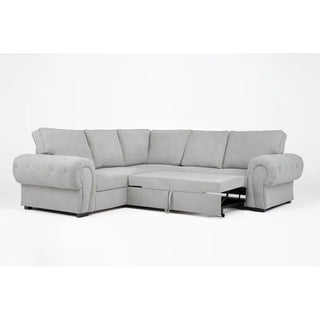 The PF Sofas SOFAINSTORE Light Grey Fabric Corner Sofa Bed features rolled arms, deep seats, tufted accents, hidden storage, and an extended pull-out bed—perfect for lounging or sleeping—shown against a plain white background.