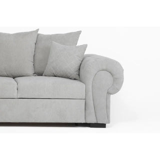 A close-up of the PF Sofas SOFAINSTORE Grey Fabric Chesterfield Corner Sofa Bed, featuring a scroll arm and three matching cushions, is shown against a plain white background. Only the right half of this pull-out sleeper with storage is visible.