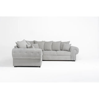 The PF Sofas SOFAINSTORE Grey Fabric Chesterfield Corner Sofa Bed features tufted sides, scroll arms, storage, a pull-out sleeper, and matching pillows; shown here in light gray against a plain white background.