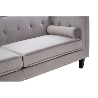 A close-up of Premier Sofas Felisen Grey Velvet 3 Seater Sofa, featuring a button-tufted design, cylindrical bolster pillow, and eucalyptus frame—ideal for anyone seeking luxury sofas UK or to buy sofas online UK.