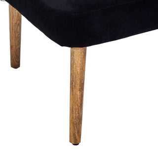 Close-up of the Nestium FURCO Boho-Inspired 2 Seater Sofa in black velvet, featuring two elegant mango wood legs and highlighting the rich fabric texture.