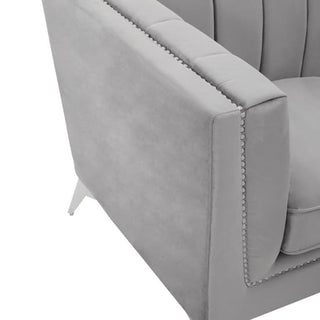 Close-up of a modern light gray upholstered armchair with vertical tufted backrest and nailhead trim—an elegant match for the Hefei Velvet 2 Seater Sofa in grey fabric with chrome metal legs by Premier Sofas.