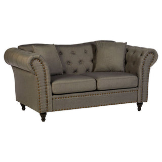 The Nestium SOFAINSTORE Kensington Grey Fabric Chesterfield 2 Seater sofa features scroll arms, a button-tufted back, studded detail, two seat cushions, matching pillows, and dark wooden legs for classic elegance.
