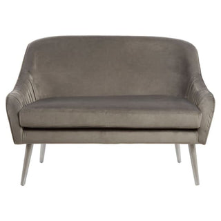 The Nestium SOFAINSTORE Light Grey Velvet Fabric 2 Seater Sofa features a shell back, smooth piping, and modern glam legs—ideal for stylish grey living rooms.