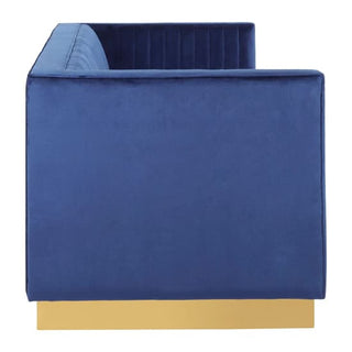 The Premier Sofas Deep Blue Velvet 3 Seater Sofa features elegant vertical tufting, a clean boxy design, and a gold base for added sophistication—modern style viewed from the side.