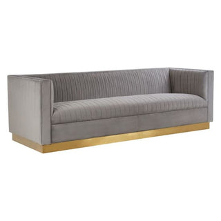 The Premier Sofas Grey Velvet 3 Seater Sofa features vertical channel tufting, a rectangular silhouette, and a gold metallic base for a modern look.