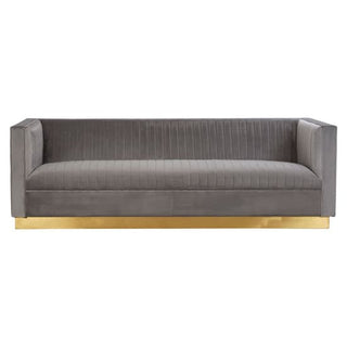The Premier Sofas Grey Velvet 3 Seater Sofa features channel tufting, boxy arms, a low back, and sits on a sleek gold base for a modern look.