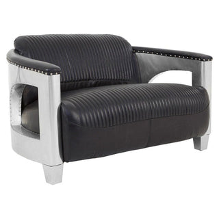 The Premier Sofas Contemporary Black Leather 2 Seater Sofa features channel tufting, aluminium arms and legs, cutout sides, and decorative studs along the armrests.