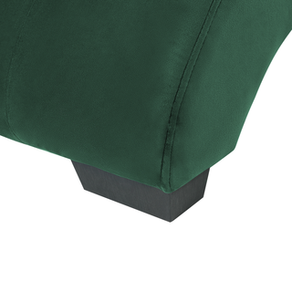 Close-up of the Beliani SOFAINSTORE Maestro Green Velvet Chaise Lounge, highlighting its emerald green velvet fabric texture and a dark wooden leg. Features include Bluetooth speakers, USB port, and a modern tech design.