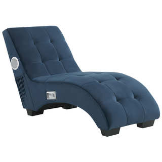 The Beliani SOFAINSTORE Blue Velvet Fabric Chaise Lounge features tufted upholstery, built-in Bluetooth speakers, a USB charging port, and a cushioned headrest, set against a white background.